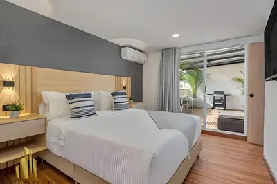 a bedroom with a large white bed and a balcony at Aria Living 502 - Luxury Terrace in Laureles in Guayaquil