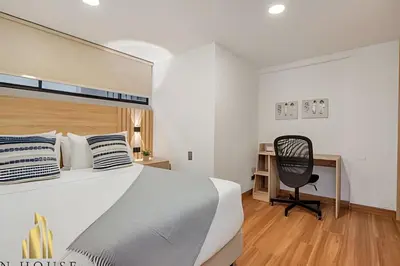 a bedroom with a bed and a desk and a chair at Aria Living 502 - Luxury Terrace in Laureles in Guayaquil