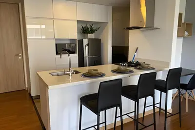 a kitchen with a counter with chairs and a kitchen island at Campestre 605 - Cozy Studio with AC and Balcony in Envigado