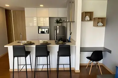 a kitchen with a counter with chairs and a kitchen island at Campestre 605 - Cozy Studio with AC and Balcony in Envigado
