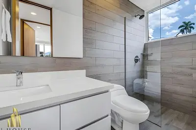 a bathroom with a toilet and a sink and a mirror at Campestre 704 - Sophisticated Apt with AC & gym in Envigado