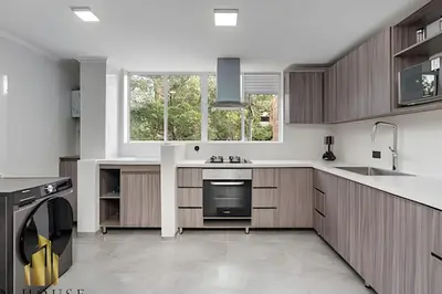 a kitchen with wooden cabinets and a large window at Caracolí 301 - Donde el Estilo Grita Libertad in El Poblado