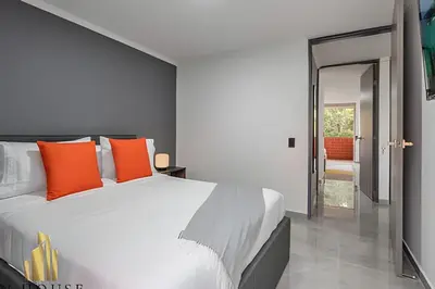 a bedroom with a large white bed with orange pillows at Caracolí 301 - Donde el Estilo Grita Libertad in El Poblado