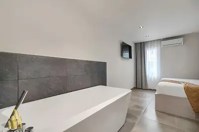 a bedroom with a white bed and a white bench at Casa Solei 12-13 - Prestigious & Priv Apt/Bath Tub in El Poblado