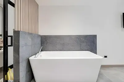 a white bath tub in a bathroom with a concrete wall at Casa Solei 12-13 - Prestigious & Priv Apt/Bath Tub in El Poblado