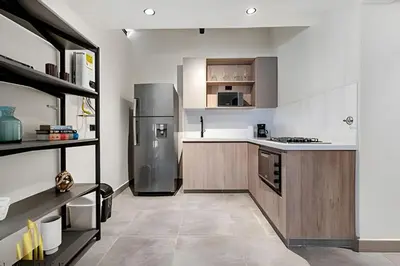 a kitchen with a stainless steel refrigerator and wooden cabinets at Casa Solei 12-13 - Prestigious & Priv Apt/Bath Tub in El Poblado
