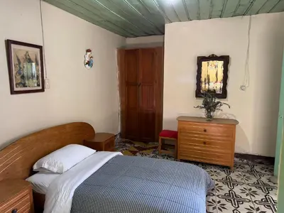 a bedroom with a bed and a dresser and a mirror at Casa colonial con encanto en Sonsón in Sonsón