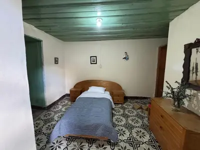 a bedroom with a bed in the corner of a room at Casa colonial con encanto en Sonsón in Sonsón