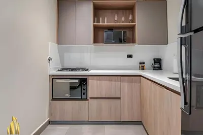 a kitchen with white counters and wooden cabinets at Casa Solei 12-3 - Prime Location: Enjoy El Poblado in El Poblado