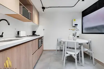 a kitchen with a table and a white table and chairs at Casa Solei 12-7 - Bright & Chic Apt in Manila / AC in El Poblado