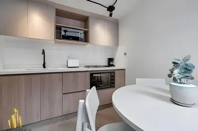a white kitchen with a white table and chairs at Casa Solei 12-7 - Bright & Chic Apt in Manila / AC in El Poblado