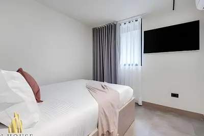a bedroom with a bed and a flat screen tv at Casa Solei 12-7 - Bright & Chic Apt in Manila / AC in El Poblado