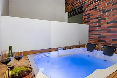 a hot tub with a bowl of grapes and wine glasses at Casa Solei 12-9 - Stylish Apt with Jacuzzi & AC in El Poblado
