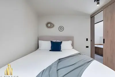 a bedroom with a large bed with a blue pillow at Casa Solei 12-9 - Stylish Apt with Jacuzzi & AC in El Poblado