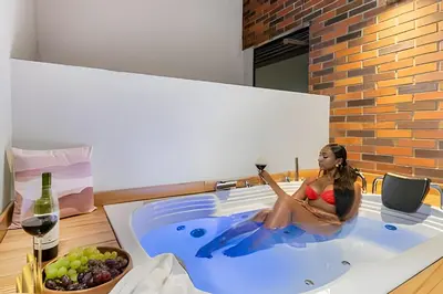 a woman sitting in a hot tub with a glass of wine at Casa Solei 12-9 - Stylish Apt with Jacuzzi & AC in El Poblado