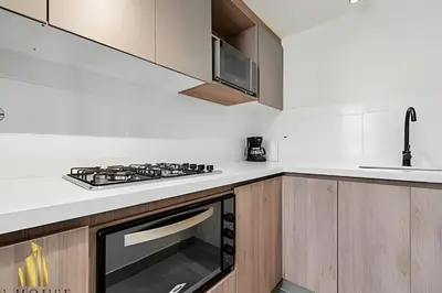 a white kitchen with a stove and a sink at Casa Solei 12-9 - Stylish Apt with Jacuzzi & AC in El Poblado