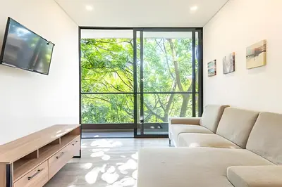 a living room with a couch and a large window at Class Suites 502 - Modern Tranquility/Priv Balcony in El Poblado