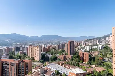 a city with tall buildings and mountains in the background at Class Suites 502 - Modern Tranquility/Priv Balcony in El Poblado