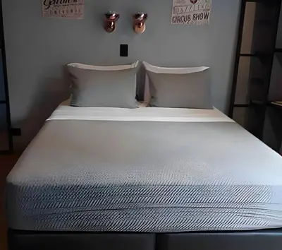 a bed with white sheets and pillows in a room at Condado 204 - Eco Apt/Natural Atmosphere in El Poblado
