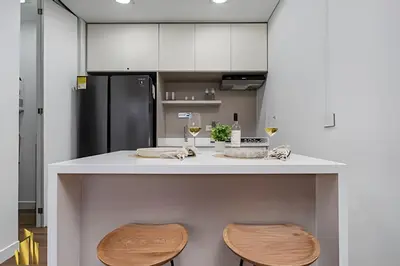 a kitchen with a white counter with two stools at Energy 403 - Prestigious Urban Oasis / Pool in El Poblado