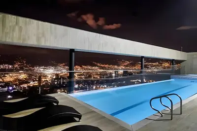 a pool with a view of a city at night at Energy 601 - Prestigious Apt/Pool & Jacuzzi in El Poblado