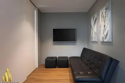 a living room with a black couch and a flat screen tv at Energy 601 - Prestigious Apt/Pool & Jacuzzi in El Poblado