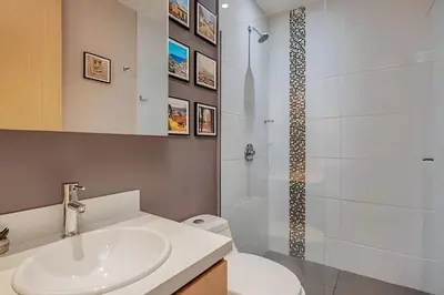 a bathroom with a white sink and a shower at Finito 1512 - Modern Apt with Views & Balcony in El Poblado