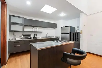 a kitchen with a counter and a chair in it at Gauss 1205-Serenity Modern Apt/Terrace/Squash/Gym in El Poblado