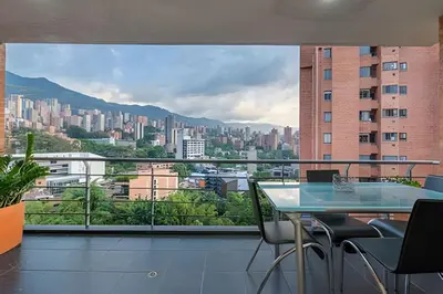 a balcony with a table and chairs and a view of a city at Gauss 1205-Serenity Modern Apt/Terrace/Squash/Gym in El Poblado