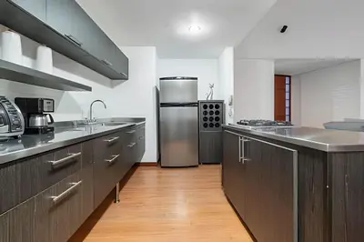a large kitchen with a stainless steel refrigerator at Gauss 1205-Serenity Modern Apt/Terrace/Squash/Gym in El Poblado