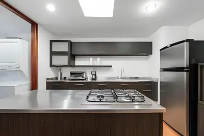 a kitchen with a stove and a stainless steel refrigerator at Gauss 1205-Serenity Modern Apt/Terrace/Squash/Gym in El Poblado