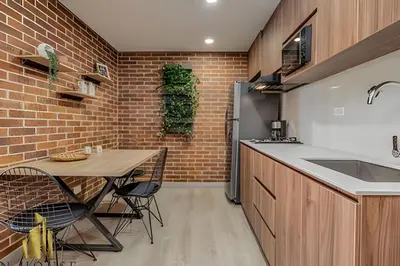 a kitchen with a table and a brick wall at Kyux 405 - The Icon of Exclusivity in Laureles in Alpujarra