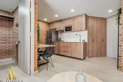 a kitchen with wooden cabinets and a dining room at Kyux 405 - The Icon of Exclusivity in Laureles in Alpujarra
