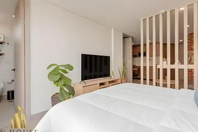 a bedroom with a white bed and a tv at Kyux 405 - The Icon of Exclusivity in Laureles in Alpujarra
