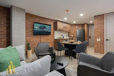a living room with a table and chairs and a kitchen at Kyux 408 - The hidden gem of Laureles in Alpujarra