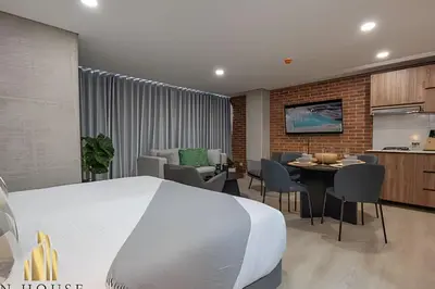 a bedroom with a large bed and a dining room at Kyux 408 - The hidden gem of Laureles in Alpujarra