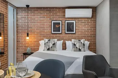 a bedroom with a bed and chairs and a brick wall at Kyux 408 - The hidden gem of Laureles in Alpujarra