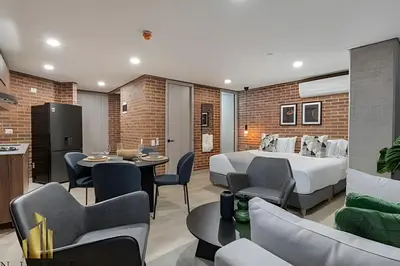a hotel room with a bed and a table and chairs at Kyux 408 - The hidden gem of Laureles in Alpujarra