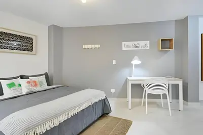 a bedroom with a bed and a table and a chair at La 70 Laureles 302 - Fresh & Well Apt/Priv balcony in Guayaquil