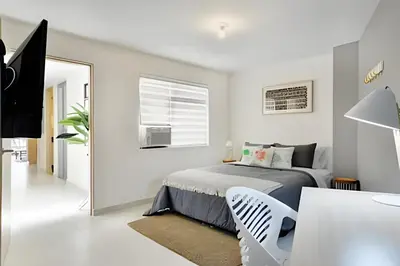 a white bedroom with a bed and a desk at La 70 Laureles 302 - Fresh & Well Apt/Priv balcony in Guayaquil