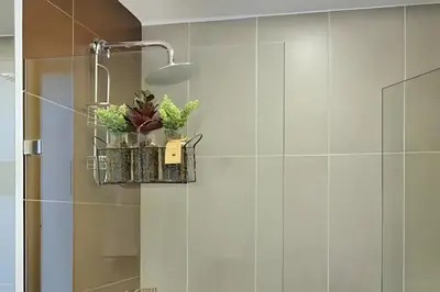 a bathroom with white tiled walls and a shower at La 70 Laureles 302 - Fresh & Well Apt/Priv balcony in Guayaquil