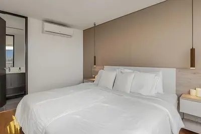 a white bed with white pillows in a bedroom at Life 1202 - Pleasant Apt in Poblado with AC in El Poblado