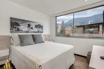 a bedroom with a large bed and a large window at Life 1202 - Pleasant Apt in Poblado with AC in El Poblado