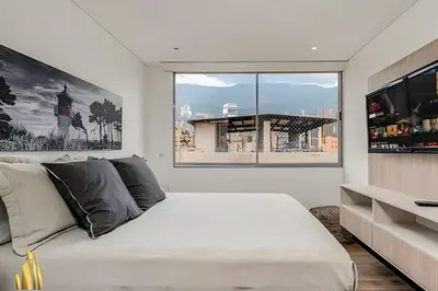 a bedroom with a large bed and a large window at Life 1202 - Pleasant Apt in Poblado with AC in El Poblado