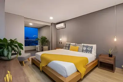 a bedroom with a large bed with a yellow blanket at Life 1603 - Panoramic & Tastefully Decorated Loft in El Poblado