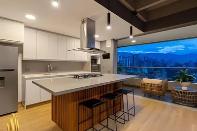 a kitchen with white cabinets and a large window at Life 1603 - Panoramic & Tastefully Decorated Loft in El Poblado