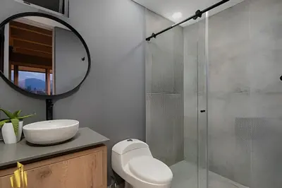 a bathroom with a shower and a sink and a mirror at Life 1603 - Panoramic & Tastefully Decorated Loft in El Poblado