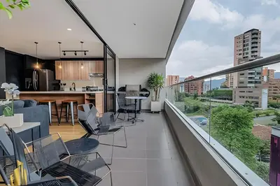 an apartment with a balcony with a kitchen and a living room at Life 801 - Exclusive & Bright Apt/pool/gym/balcony in El Poblado
