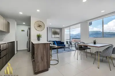 a kitchen and dining room with a clock on the wall at Metropolitan 2226-Familiar Bright Apt/Priv balcony in El Salvador