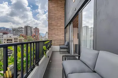 a balcony with couches and a view of a city at Morph 1101 - Sophisticated & brigh apt/ BBQ in El Poblado